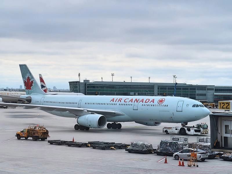 Air Canada aircraft and Dubai International Airport amid changes to UAE flight schedules