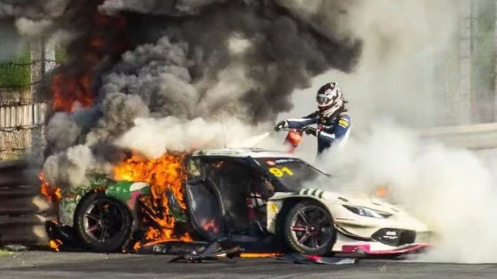 Loek Hartog uses a fire extinguisher while rescuing Ollie Millroy from a burning Ferrari during a China GT race in Shanghai.